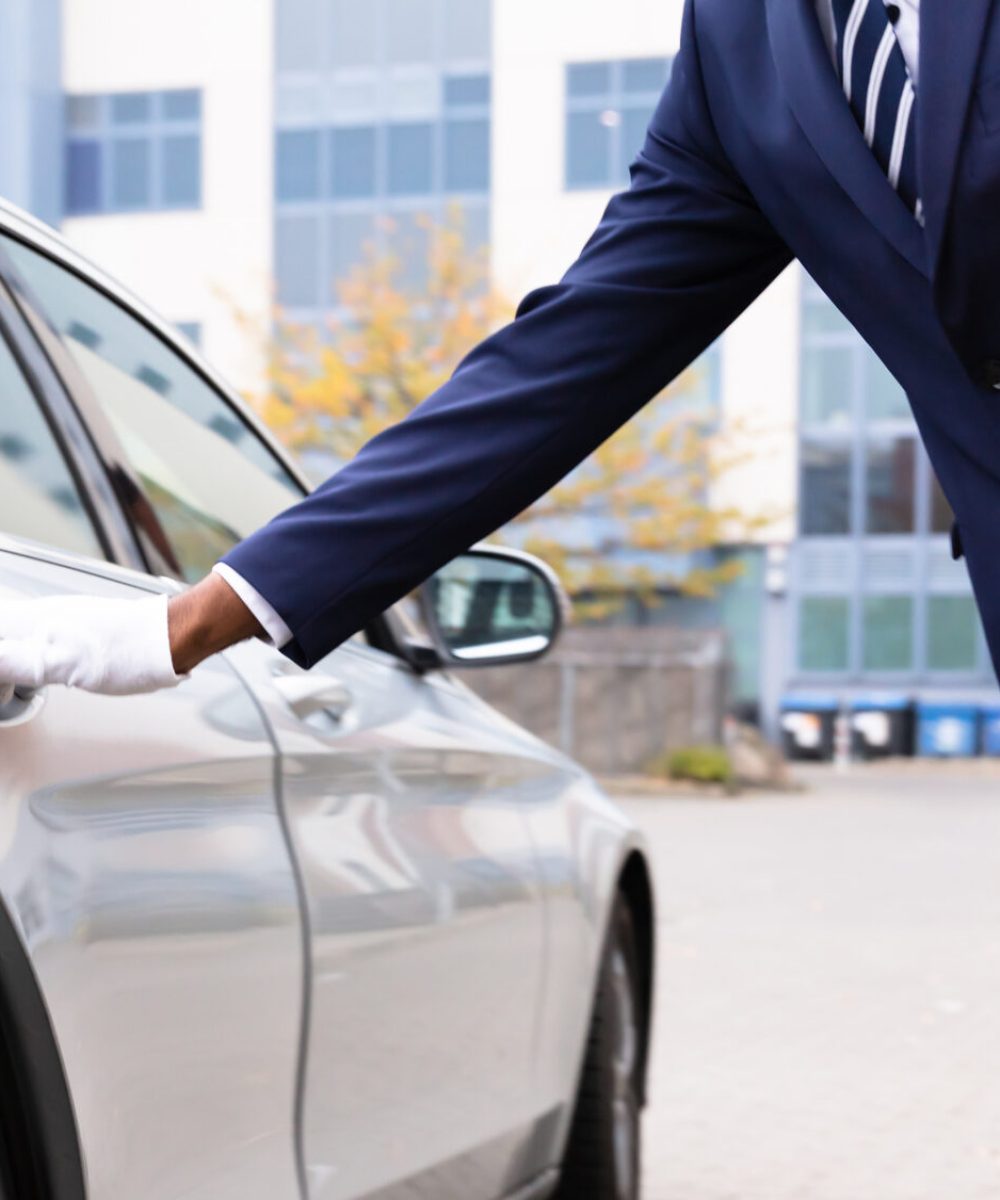Valet's Hand Opening Grey Car Door On Street